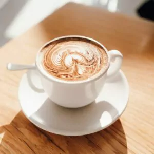 white ceramic cup with saucer on brown wooden table